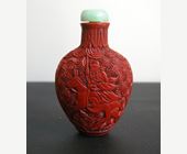 Snuff Bottles : cinnabar lacque snuff bottle on metal decorated and sculpted with a rider on one side and characters on a trolley on the other 
China 19th century
H 6,8 cm