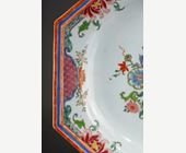 Polychrome : Plat en porcelaine de la famille rose a decor mobiliers et de fleurs - Chine Epoque Yongzheng 1723/1735