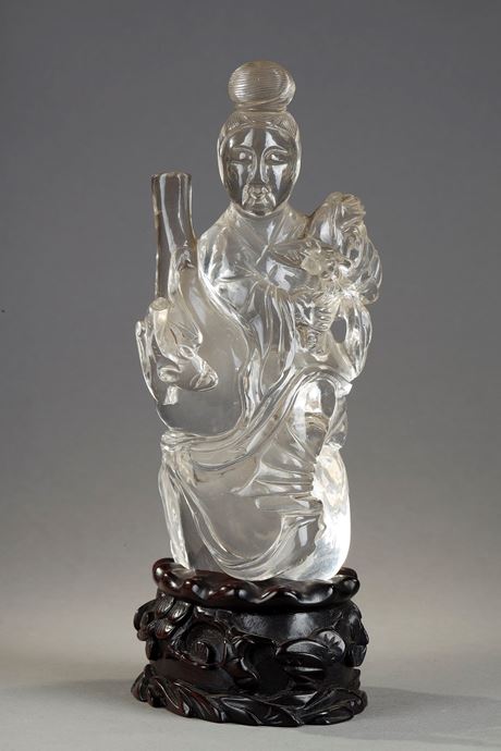 Works of Art : rock crystal figure representing a guanyin holding a vase and a flower - China around 1900
Wooden base