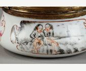 Objets d'art : Petite boite en porcelaine à decor d une femme dénudée et d un jeune serviteur  en grisaille scène inspirée de Claude Duflos père - Monture en métal doré - Chine vers 1755
H 3,5cm Diam 7 cm