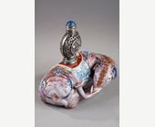 Snuff Bottles : Elephant figure lying in porcelain carrying on its back a silver snuffbottle reticulated in the spirit of Mongolia most probably from the Beijing Imperials workshops and specially adapted for the back of the elephant-
Circa 1790/1820