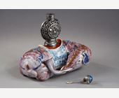 Polychrome : Elephant figure lying in porcelain carrying on its back a silver snuffbottle reticulated in the spirit of Mongolia most probably from the Beijing Imperials workshops and specially adapted for the back of the elephant-
Circa 1790/1820