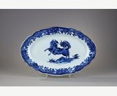 Bleu-Blanc : Petit plat à bord contournés en porcelaine bleu blanc portant un décor d un chien  probablement un epagneul
dressé sur ses pattes arrières sur un sol ou pousse des champignons Lingzi  - Chine epoque Qianlong 1736/1795  