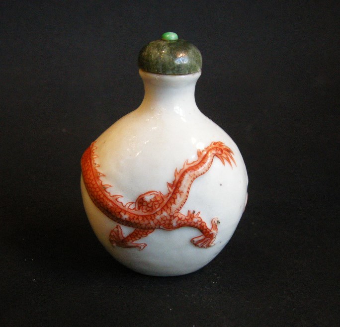 Tabatières : tabatiere en porcelaine décorée en rouge de fer d un dragon en leger relief  . Chine marque et periode Daoguang 