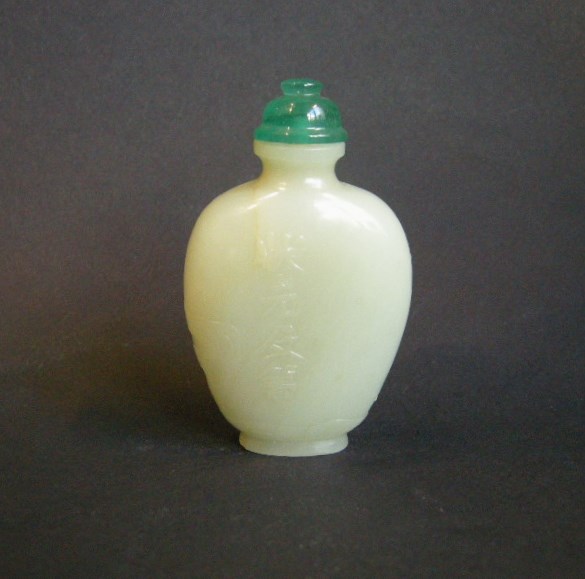 Snuff Bottles : Jade snuff bottle sculpted in a face with birds and prunus  and other face with for caracters  "can you be first laureat" 
1750/1850