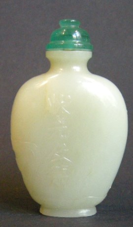 Snuff Bottles : Jade snuff bottle sculpted in a face with birds and prunus  and other face with for caracters  "can you be first laureat" 
1750/1850