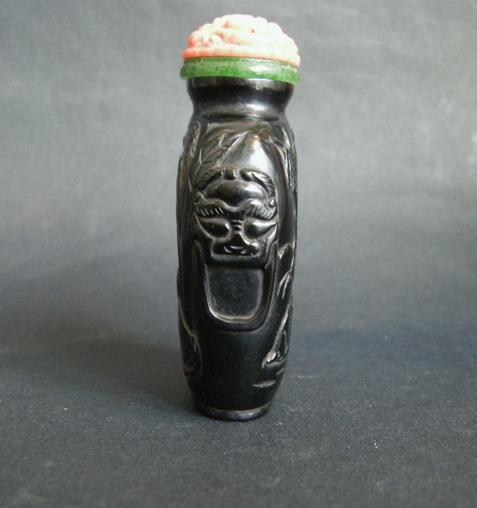 Snuff Bottles : snuff bottle "jais"   sculpted in low relief  with a cat looking a butterfly  and other face with two rabbits . Mask on the sides - 19th century - 