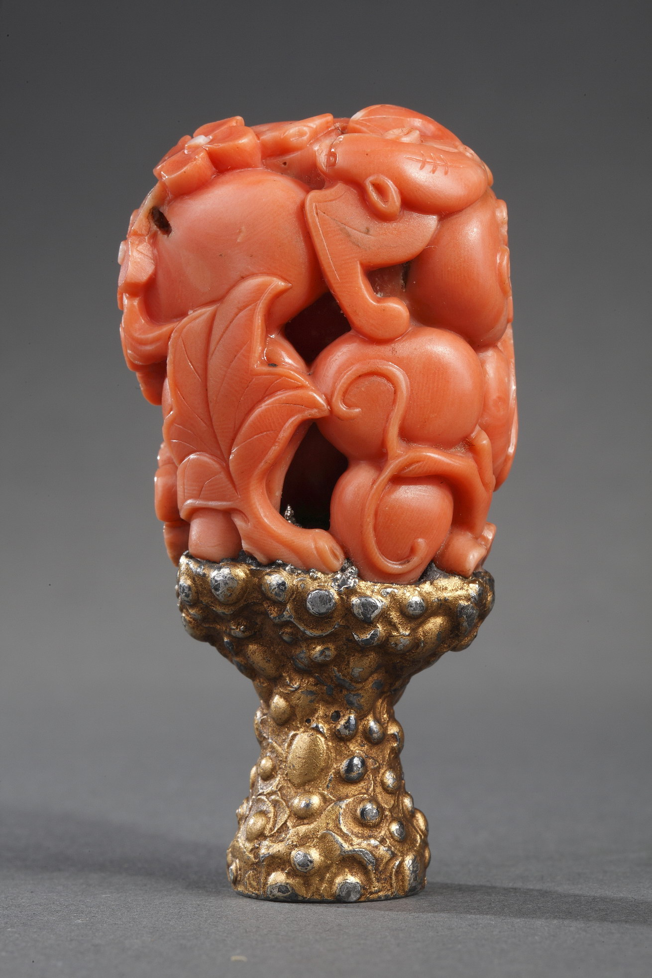 Works of Art : for double gour shaped Chinese coral  carved with flowers  leaves bat and mounted as a seal (extremity missing) . 18th century  and 19th century for the foot -    
H 4cm for the coral and 6,5cm with the foot