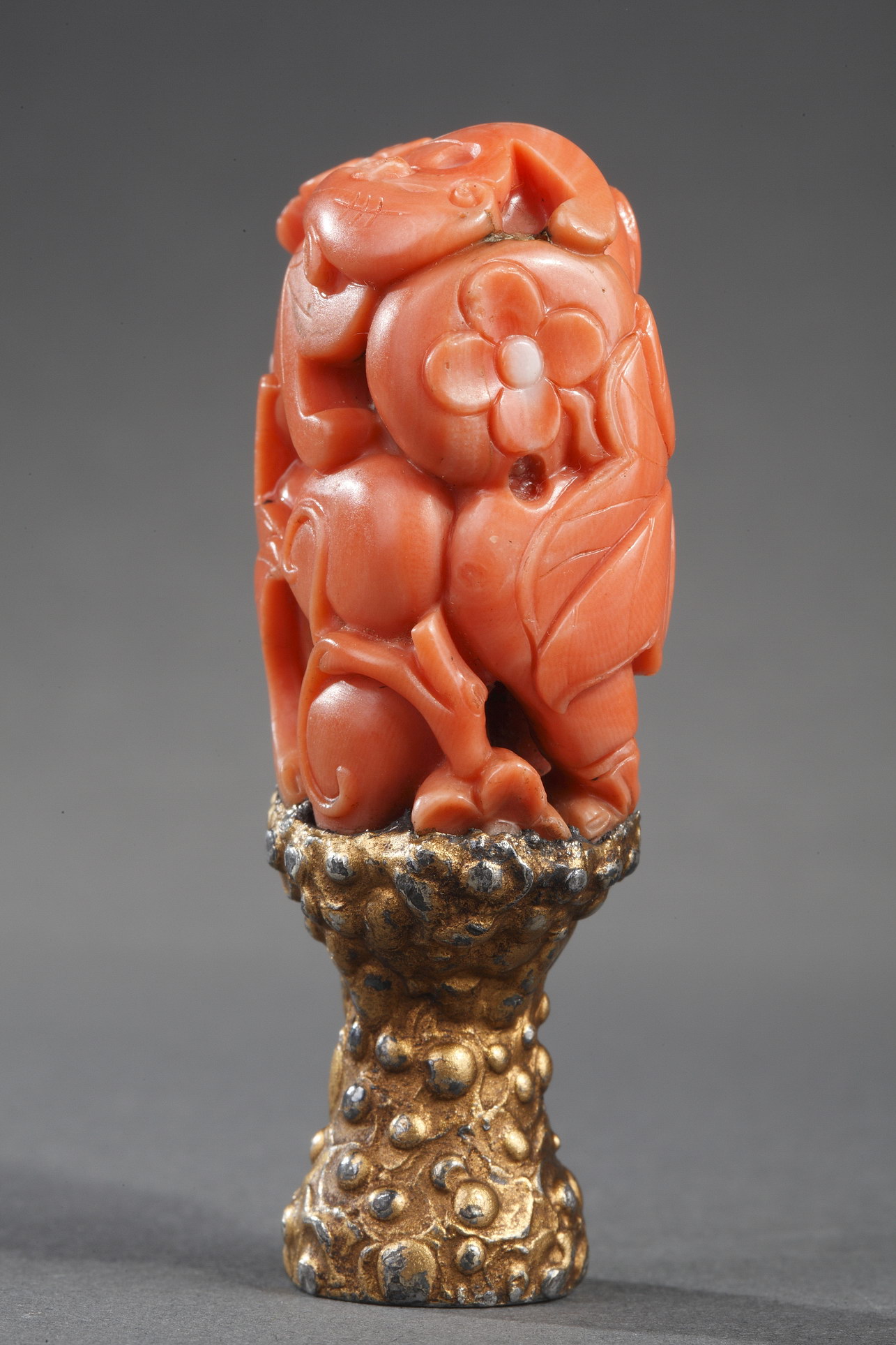 Works of Art : for double gour shaped Chinese coral  carved with flowers  leaves bat and mounted as a seal (extremity missing) . 18th century  and 19th century for the foot -    
H 4cm for the coral and 6,5cm with the foot