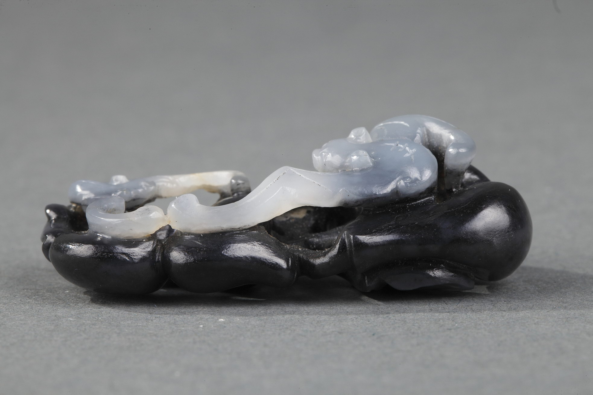 Works of Art : Pendant nephite black and white carved in the shape of two bats with double gourds and their foliage 
Circa 1900