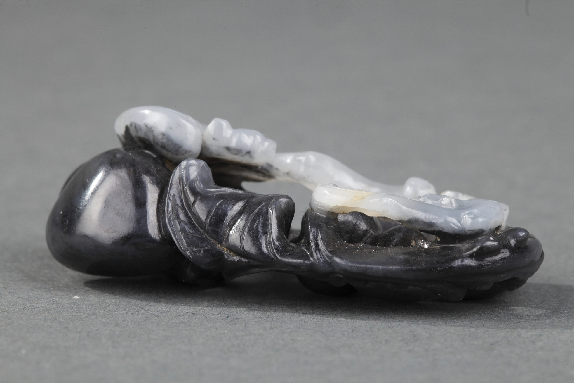 Works of Art : Pendant nephite black and white carved in the shape of two bats with double gourds and their foliage 
Circa 1900