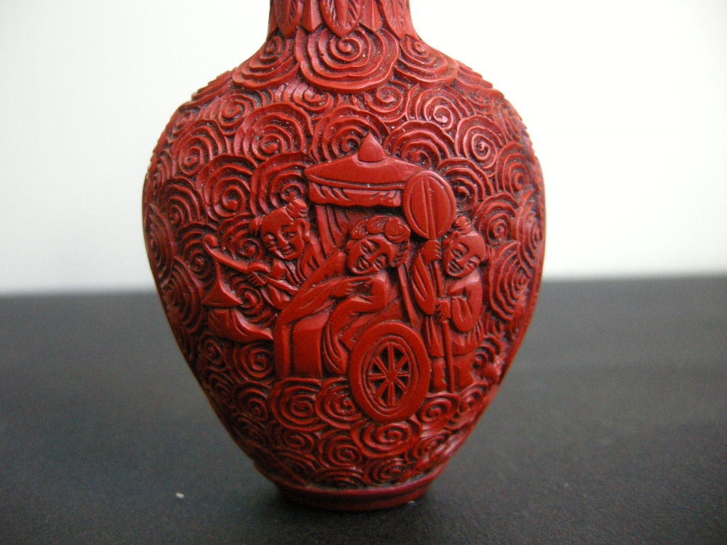 Snuff Bottles : cinnabar lacque snuff bottle on metal decorated and sculpted with a rider on one side and characters on a trolley on the other 
China 19th century
H 6,8 cm