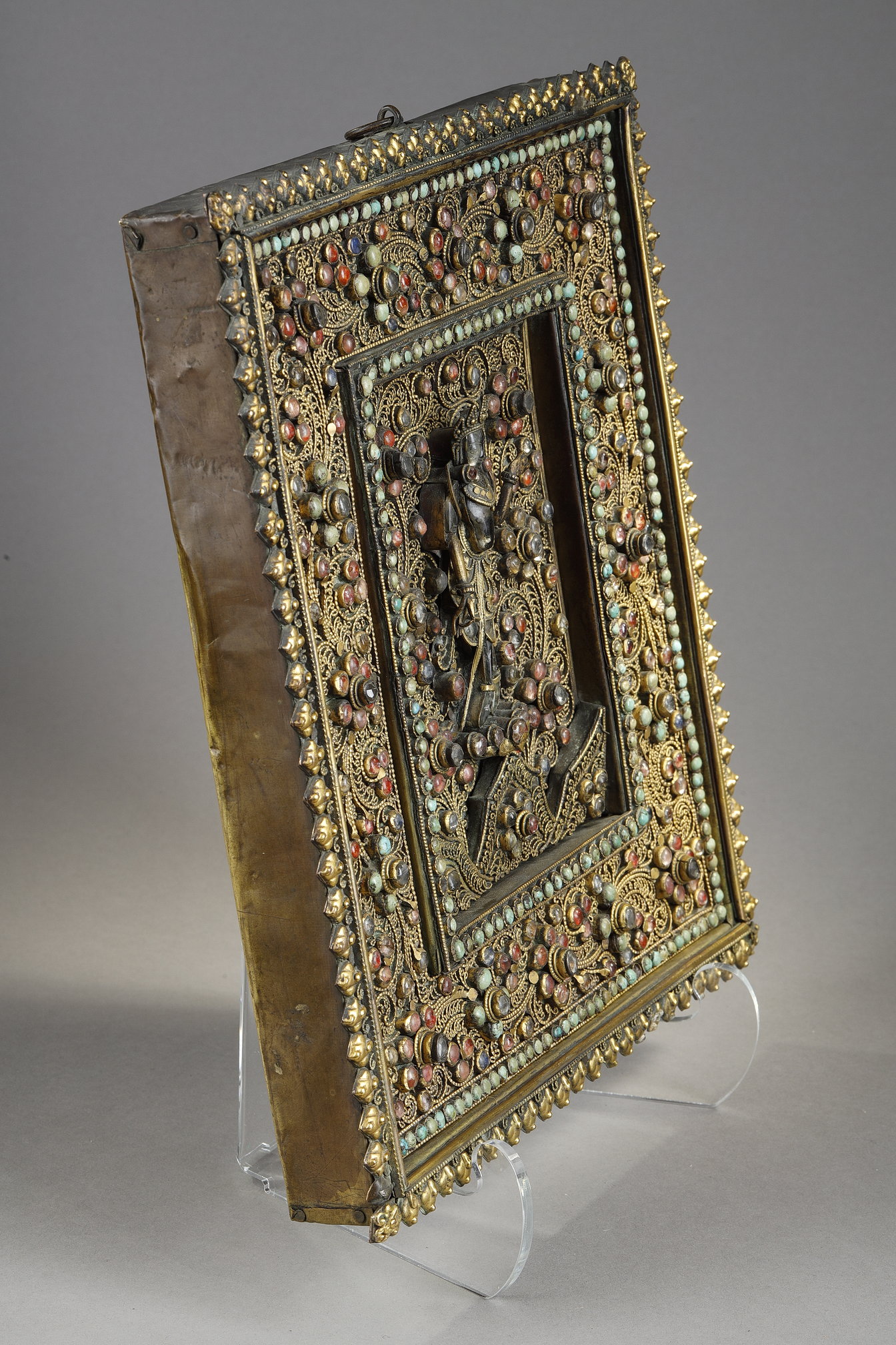 Objets d'art : Rare plaque murale votive en bois finement recouverte de filigranes en metal doré  et incrusté de cabochons turquoises , cristaux de roche, tourmalines  et au centre une deesse en cristaux de roche et metal doré. Nepal 19em siecle vers 1820