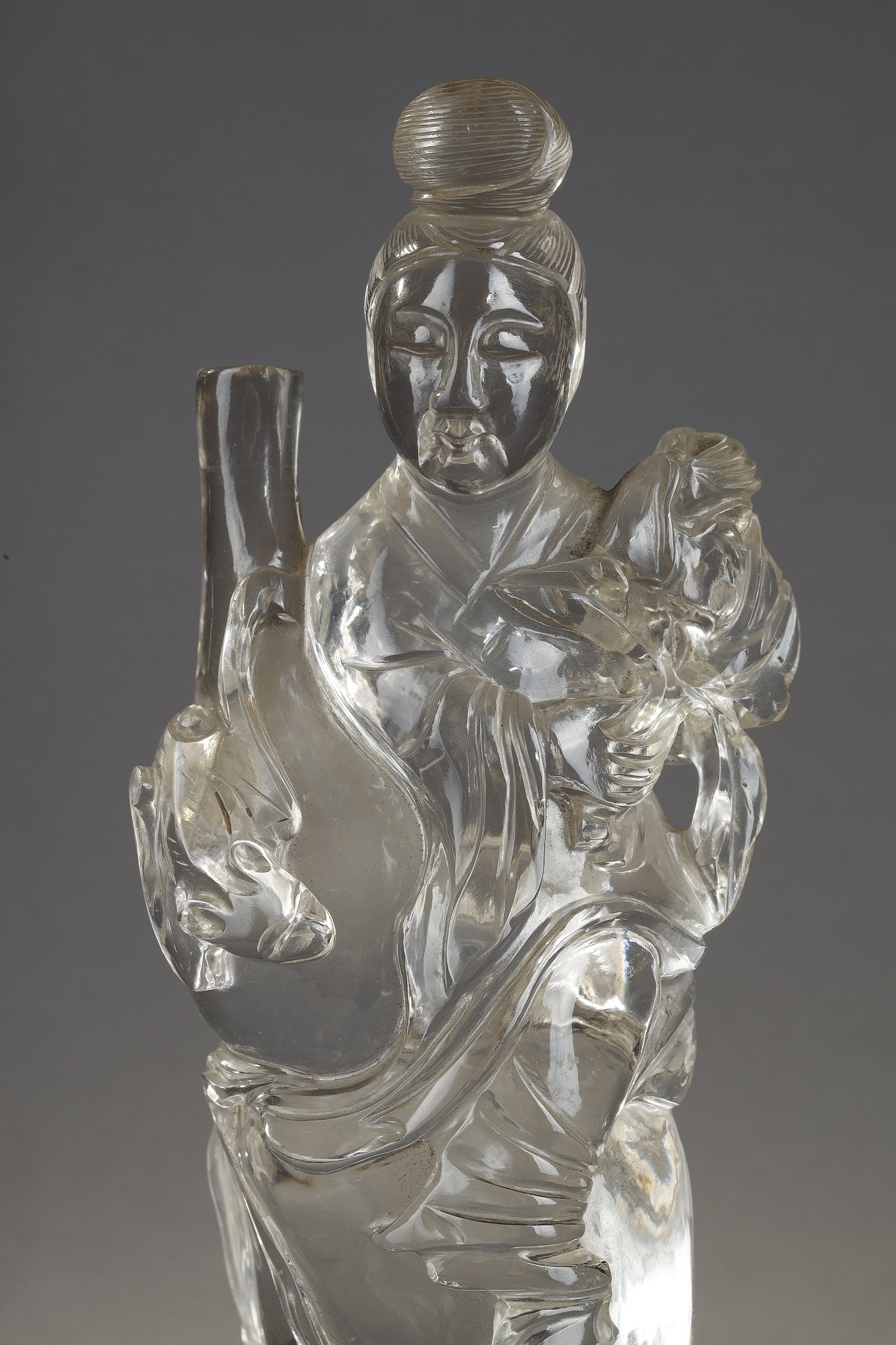 Works of Art : rock crystal figure representing a guanyin holding a vase and a flower - China around 1900
Wooden base