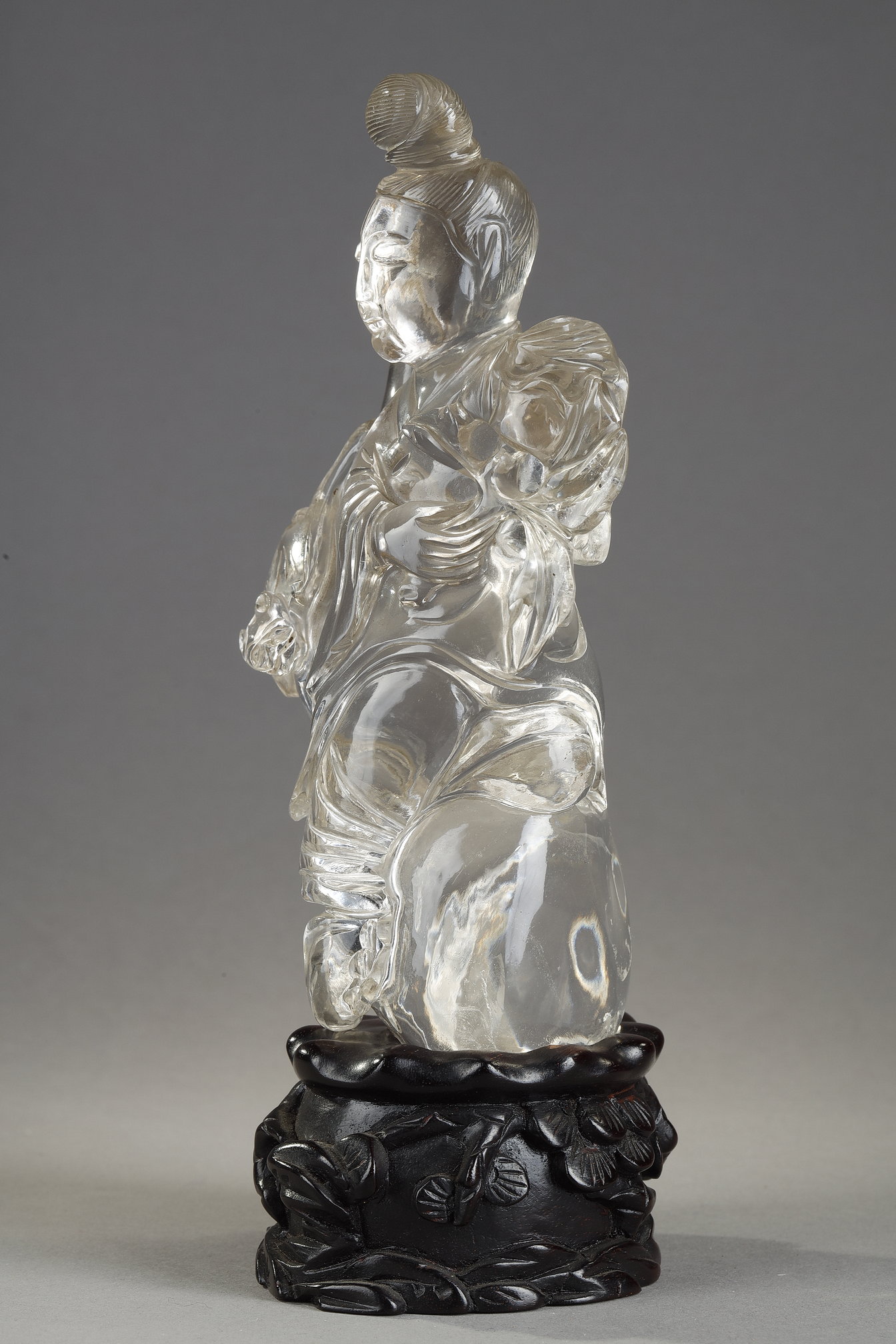 Works of Art : rock crystal figure representing a guanyin holding a vase and a flower - China around 1900
Wooden base