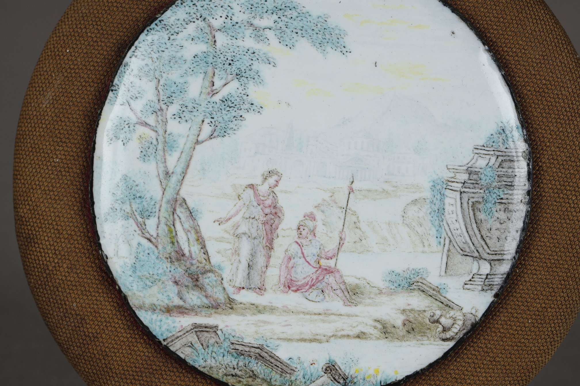 Works of Art : A Small Mid-18th Century English Enamel on Copper Circular Plaque, Probably Birmingham or Battersea. Finely painted using muted colours with a classical scene of a soldier seated next to a standing woman, to their left is a large overgrown urn and the remnants of classical objects can be seen scattered around in the foreground. The hazy distance is depicted in feint blue with an Italian landscape under a yellow sky. The back is inscribed and dated 1867. The inscription “This belonged to Sarah Duchess of Richmond who died in 1751 & was given to me by her granddaughter …(illegible)… aunt Lady Louisa in 1790 when I was 7 years old. I give it to my granddaughter Emily L. M (Bunbury?) aged 6 in 1867.”. It is then inscribed by Emily with her maiden name underneath (difficult to read). Sarah Lennox, Duchess of Richmond (née Cadogan; September 1705 – 25 August 1751), was Lady of the Bedchamber to Queen Caroline from 1724 to 1737. She was a collector and was the mother of the Lennox sisters. Below is a painting of The Duke and the Duchess of Richmond, by Jonathan Richardson. This portrait was made at the request of the Duke’s grandmother Louise de Kérouaille, who wanted a portrait of her grandson and his wife.

Diameter of enamel on copper 5 cm 