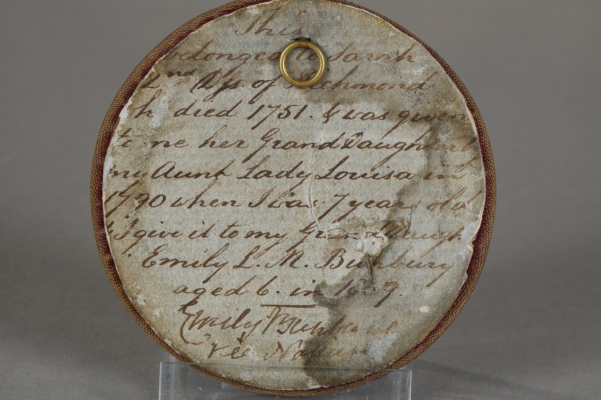 Works of Art : A Small Mid-18th Century English Enamel on Copper Circular Plaque, Probably Birmingham or Battersea. Finely painted using muted colours with a classical scene of a soldier seated next to a standing woman, to their left is a large overgrown urn and the remnants of classical objects can be seen scattered around in the foreground. The hazy distance is depicted in feint blue with an Italian landscape under a yellow sky. The back is inscribed and dated 1867. The inscription “This belonged to Sarah Duchess of Richmond who died in 1751 & was given to me by her granddaughter …(illegible)… aunt Lady Louisa in 1790 when I was 7 years old. I give it to my granddaughter Emily L. M (Bunbury?) aged 6 in 1867.”. It is then inscribed by Emily with her maiden name underneath (difficult to read). Sarah Lennox, Duchess of Richmond (née Cadogan; September 1705 – 25 August 1751), was Lady of the Bedchamber to Queen Caroline from 1724 to 1737. She was a collector and was the mother of the Lennox sisters. Below is a painting of The Duke and the Duchess of Richmond, by Jonathan Richardson. This portrait was made at the request of the Duke’s grandmother Louise de Kérouaille, who wanted a portrait of her grandson and his wife.

Diameter of enamel on copper 5 cm 