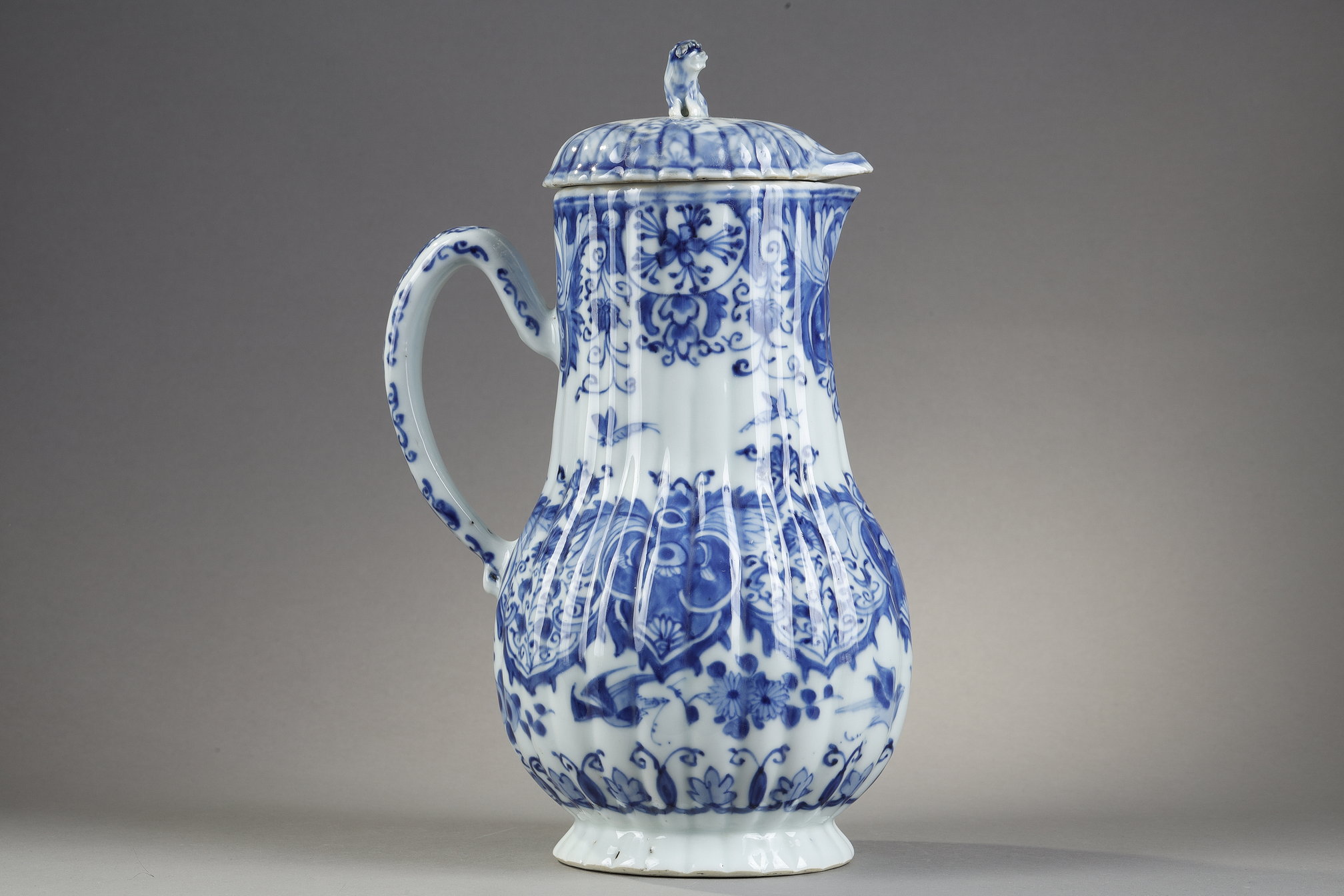 Blue White :  blue and white porcelain jug and cover decorated with butterfly birds flowers and lambrequins in the taste of Delft . On the cover the dog shape - China epoque Kangxi 1662/1722 around 1700 1720