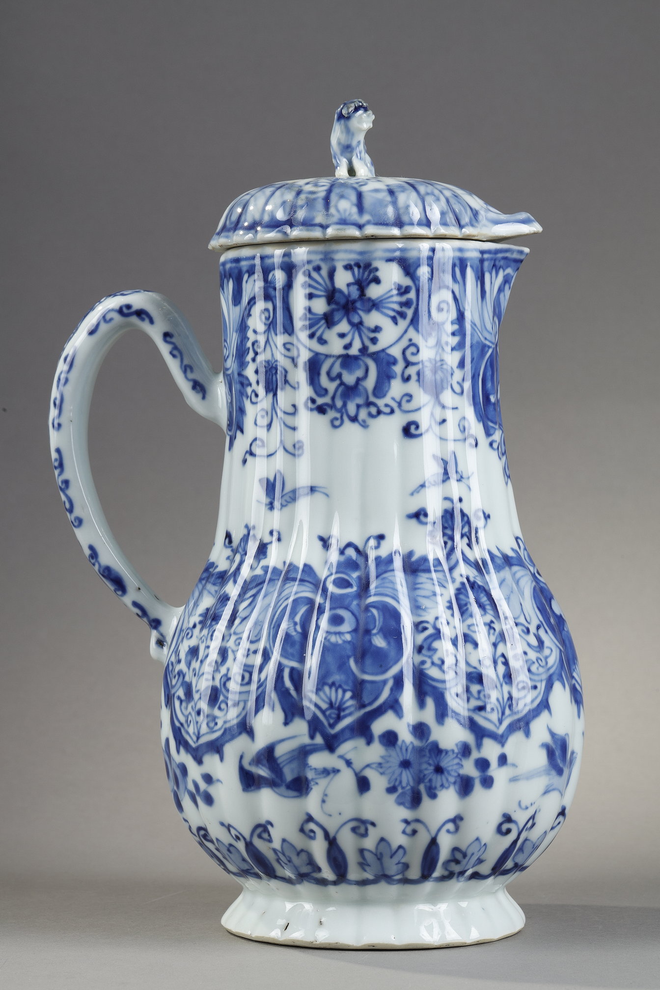 Blue White :  blue and white porcelain jug and cover decorated with butterfly birds flowers and lambrequins in the taste of Delft . On the cover the dog shape - China epoque Kangxi 1662/1722 around 1700 1720