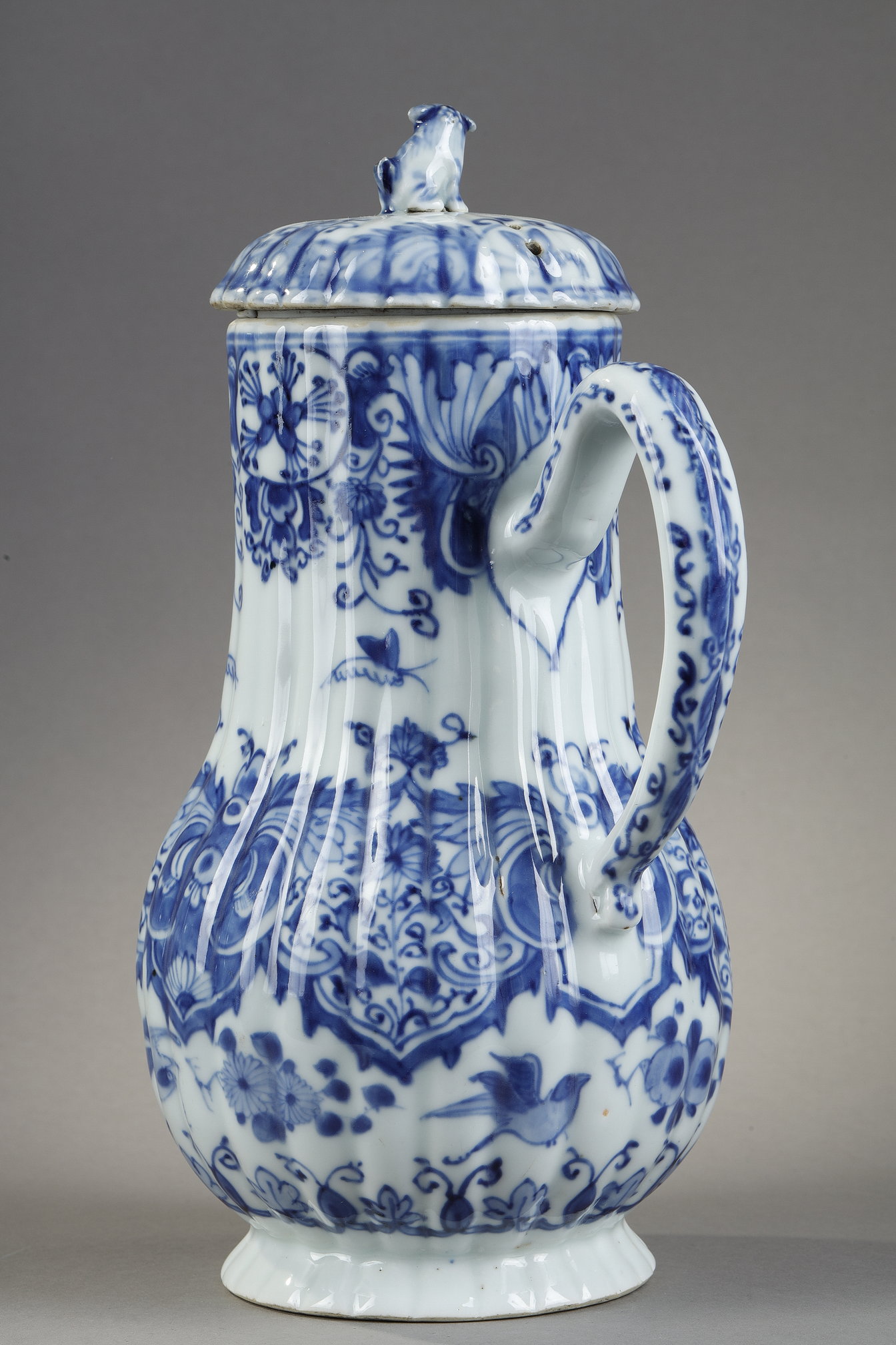 Blue White :  blue and white porcelain jug and cover decorated with butterfly birds flowers and lambrequins in the taste of Delft . On the cover the dog shape - China epoque Kangxi 1662/1722 around 1700 1720