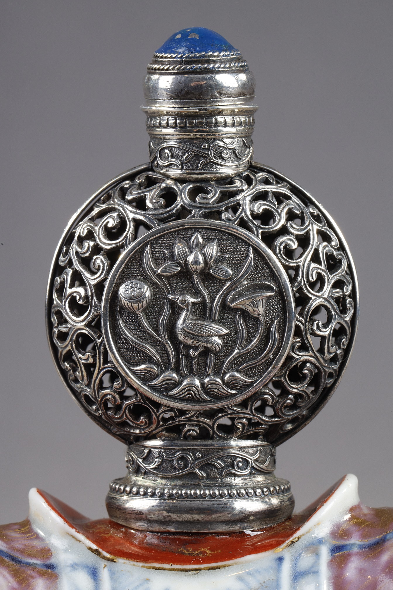 Snuff Bottles : Elephant figure lying in porcelain carrying on its back a silver snuffbottle reticulated in the spirit of Mongolia most probably from the Beijing Imperials workshops and specially adapted for the back of the elephant-
Circa 1790/1820