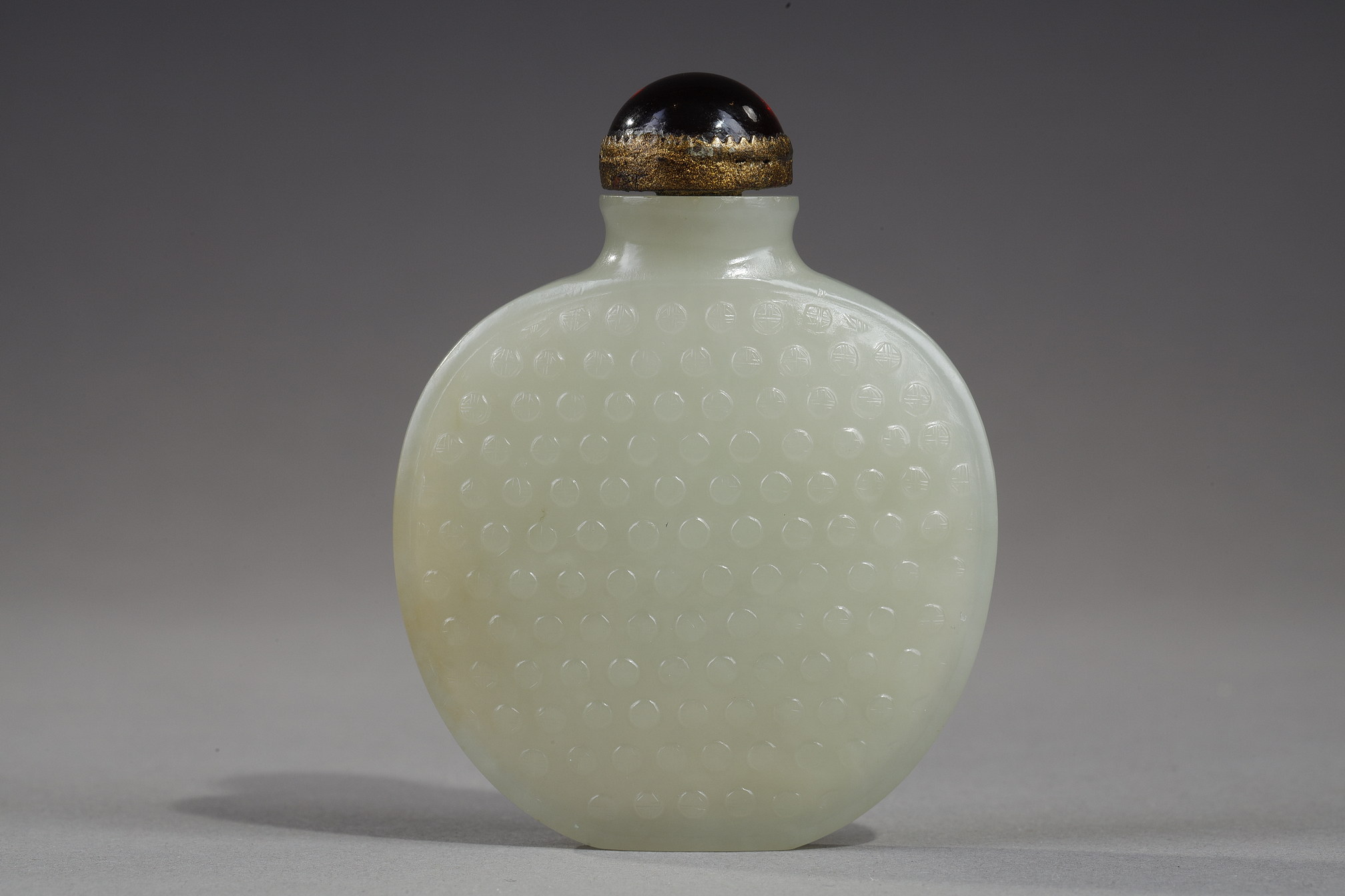 Snuff Bottles : Snuff bottle of oval shape flattened jade nephrite celadon decorated with numerous signs "Shou"
(longevity) in light relief - China 1750/1820