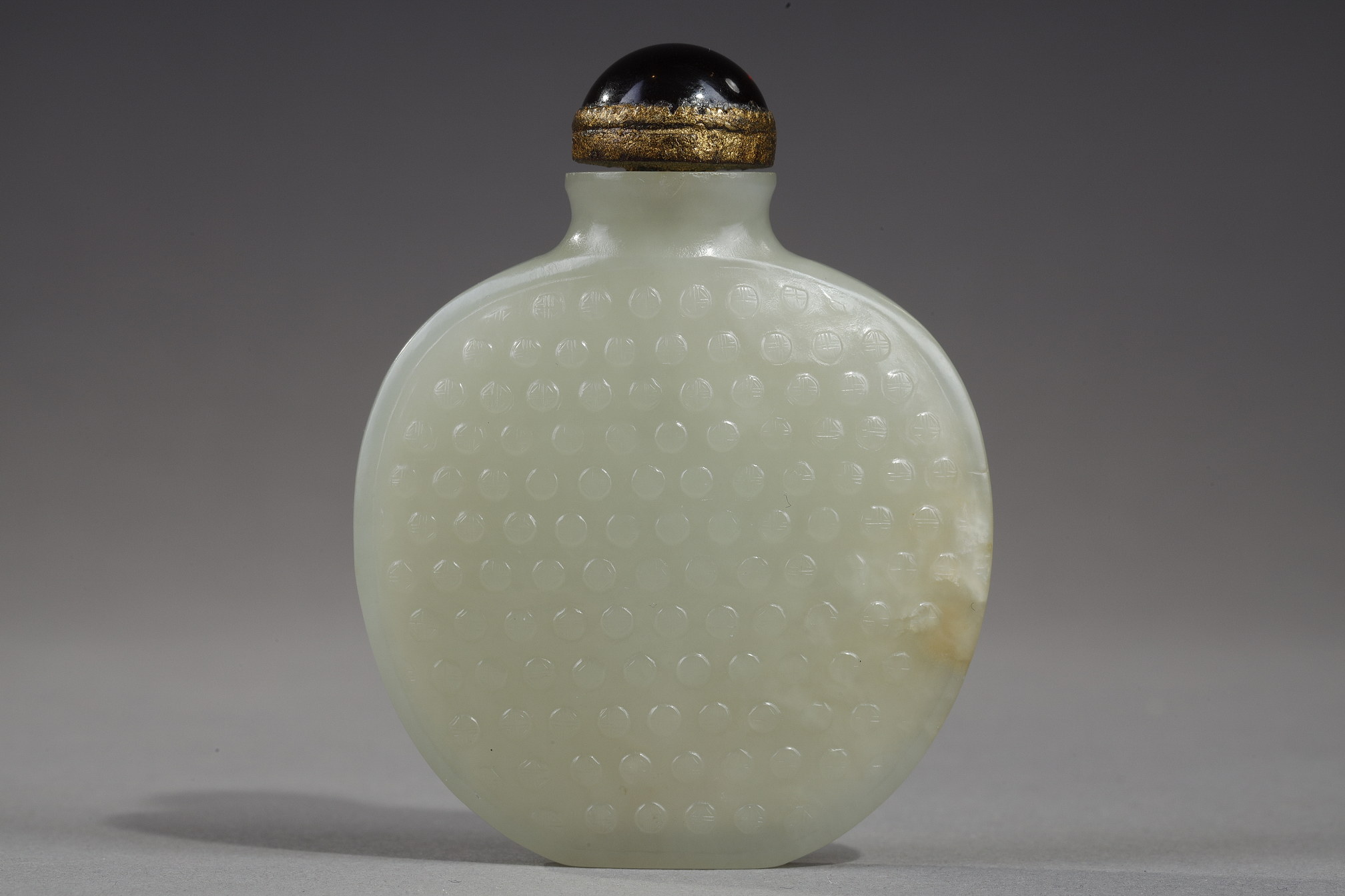 Snuff Bottles : Snuff bottle of oval shape flattened jade nephrite celadon decorated with numerous signs "Shou"
(longevity) in light relief - China 1750/1820