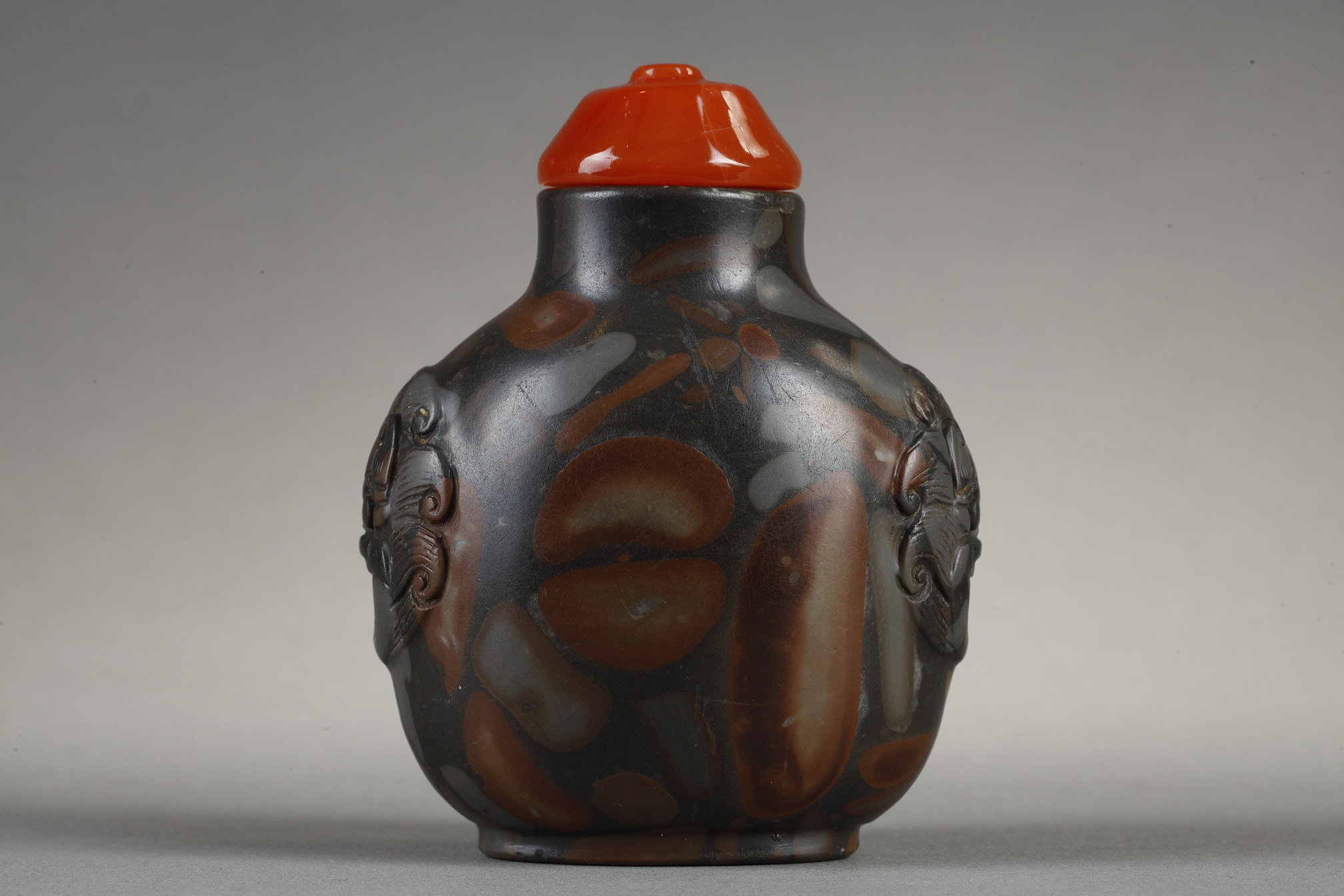Snuff Bottles : Snuff bottle in puddingstone  sculpté de masques sur les cotés
Chine 19th century 