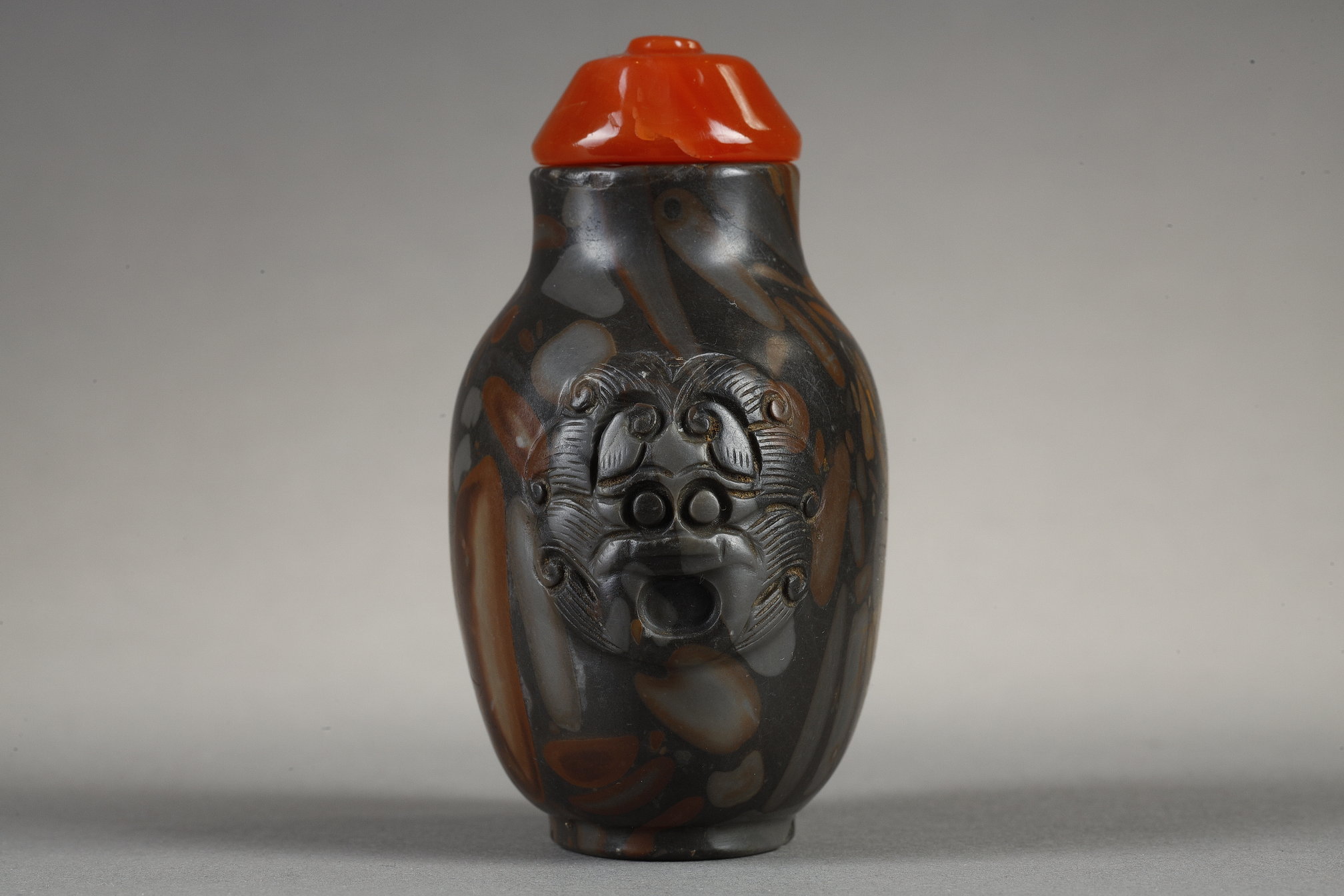Snuff Bottles : Snuff bottle in puddingstone  sculpté de masques sur les cotés
Chine 19th century 