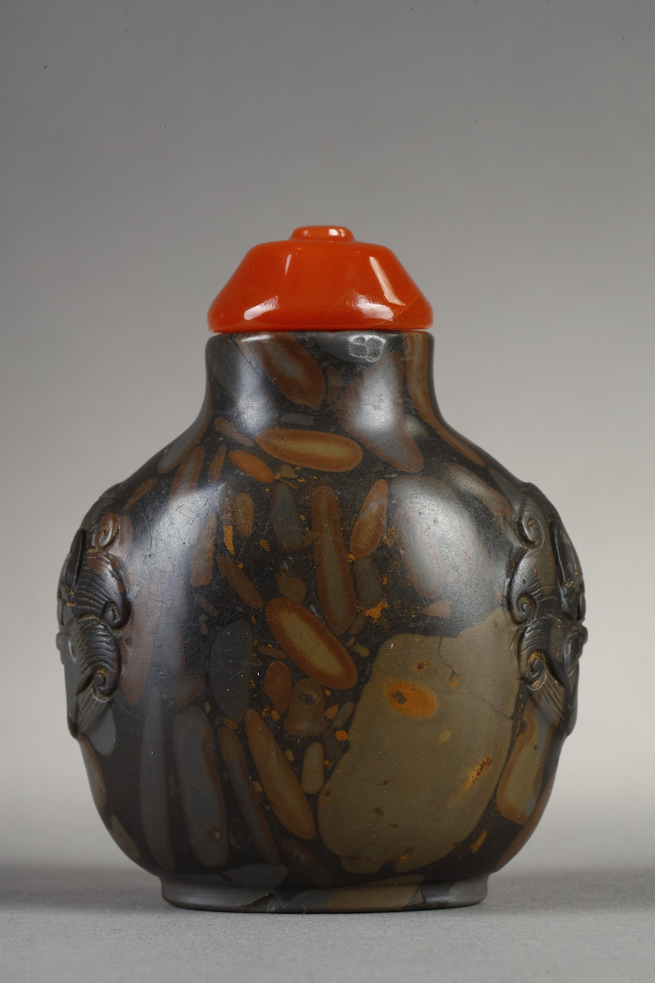 Snuff Bottles : Snuff bottle in puddingstone  sculpté de masques sur les cotés
Chine 19th century 