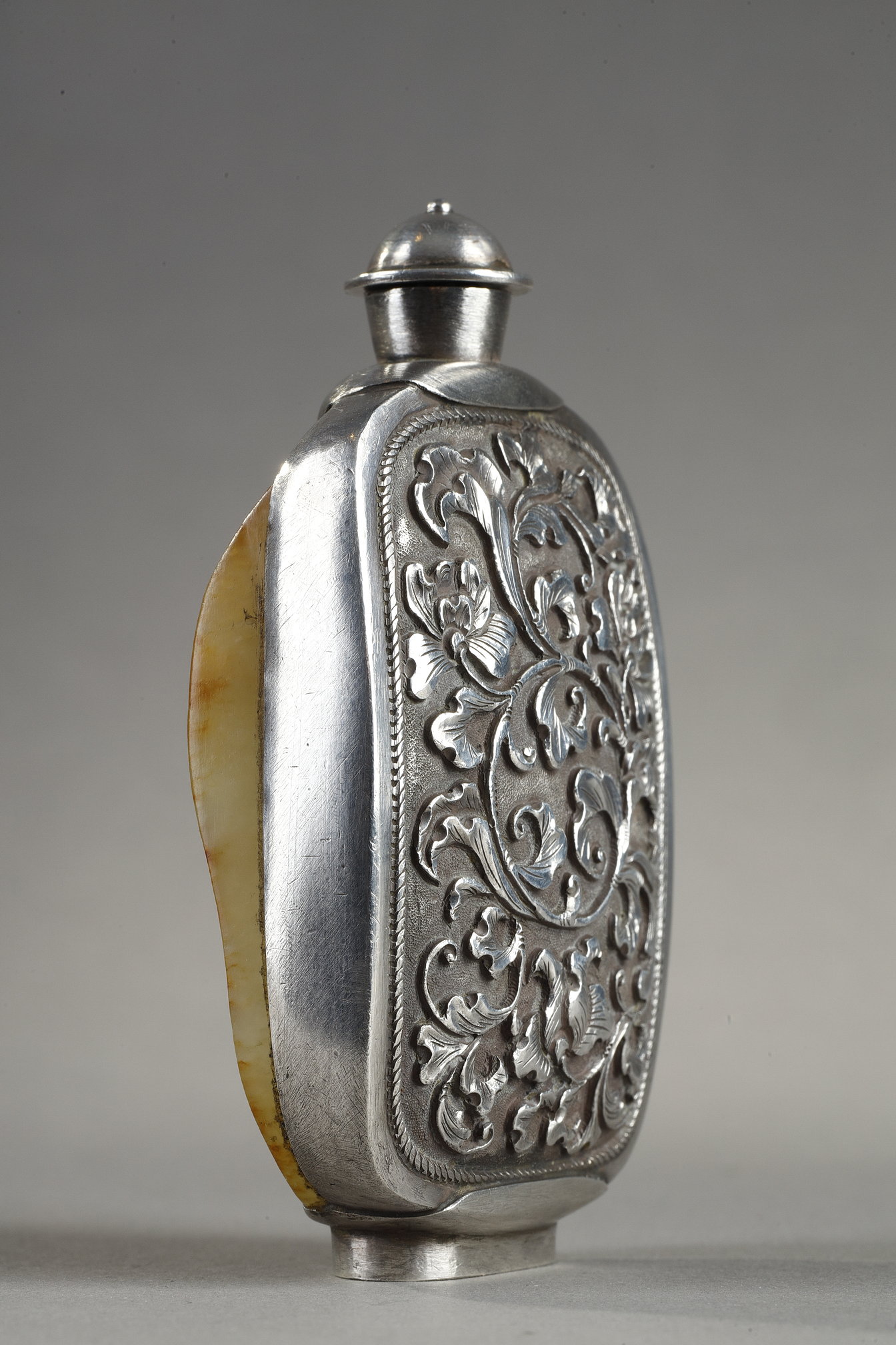 Snuff Bottles : Snuff bottle in the form of a speckled rusty jade pebble (1750/1850) included in a silver frame 
ciseled from the stem of leaves (late Qing period) -
