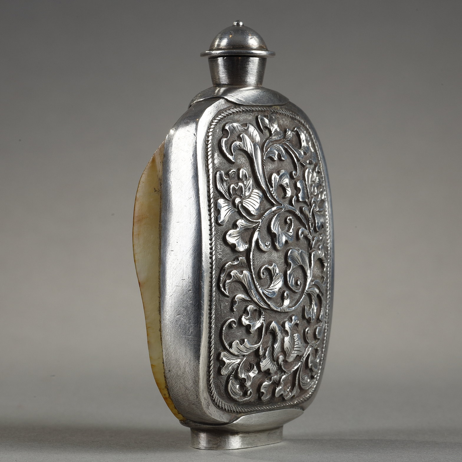 Snuff Bottles : Snuff bottle in the form of a speckled rusty jade pebble (1750/1850) included in a silver frame 
ciseled from the stem of leaves (late Qing period) -