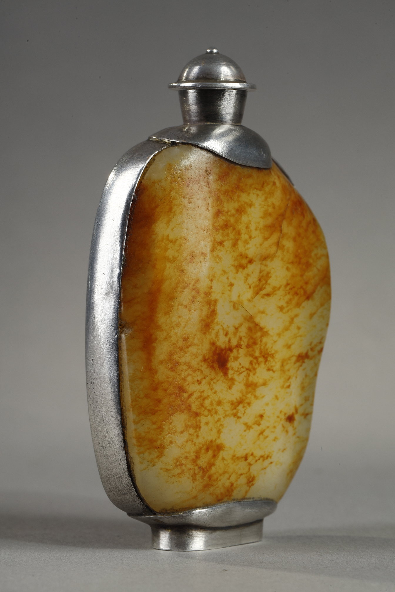 Snuff Bottles : Snuff bottle in the form of a speckled rusty jade pebble (1750/1850) included in a silver frame 
ciseled from the stem of leaves (late Qing period) -