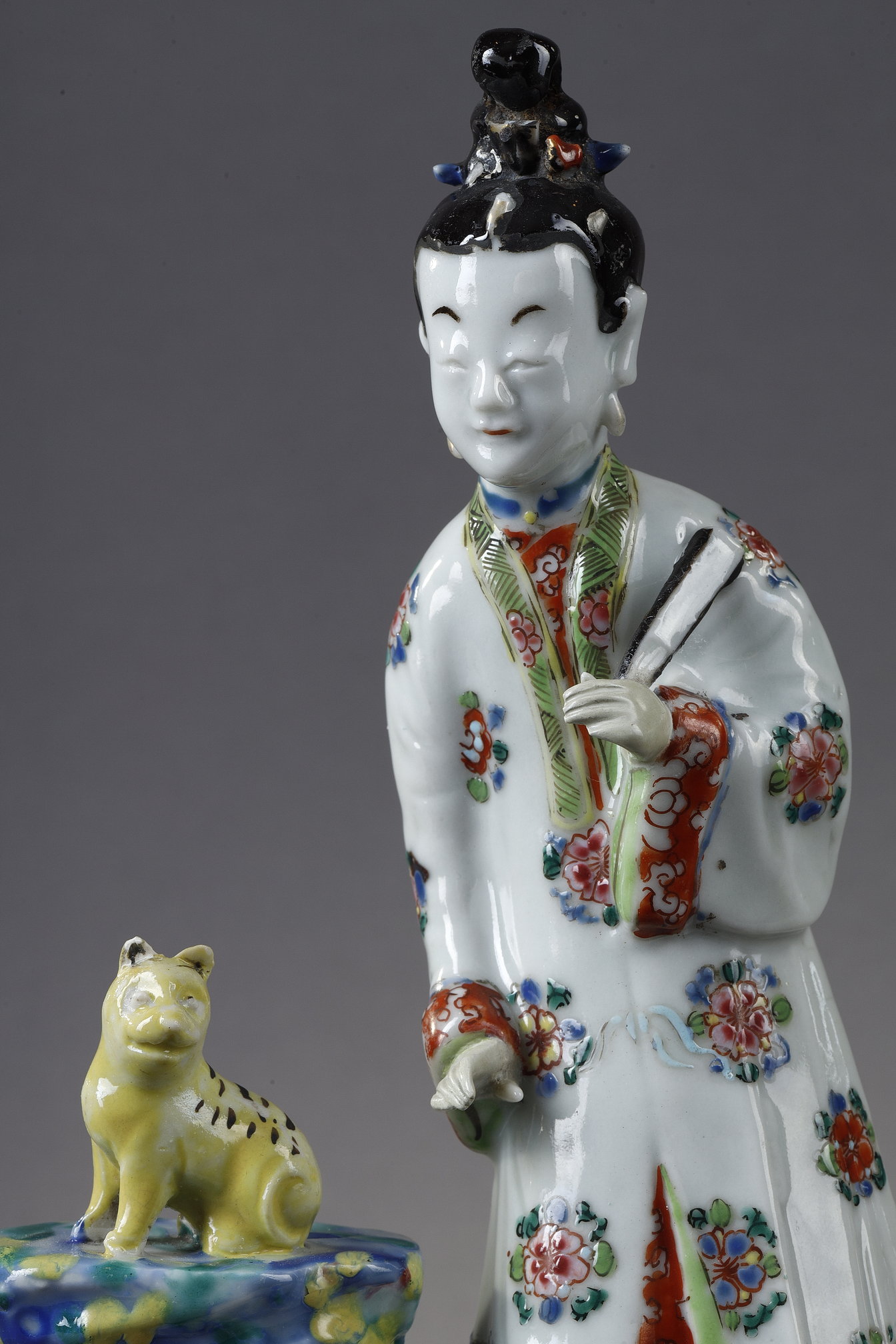 Polychrome : Porcelain group depicting a court woman standing and holding a fan next to a cat sitting on a rock. China around 1730 -   
H 22cm