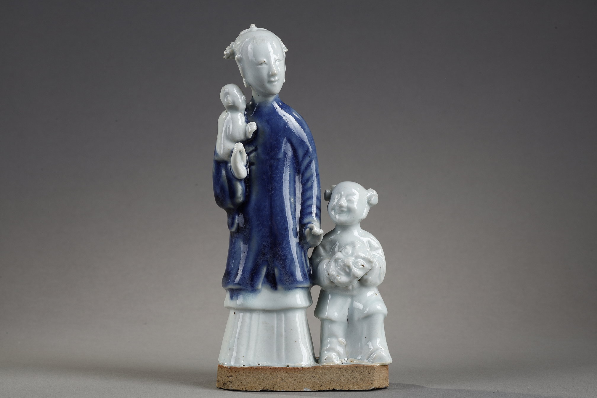 Blue White : charming blue white porcelain group of a young woman holding a baby and next to a child carrying in her arms a mask
China  Qianlong period  around 1750