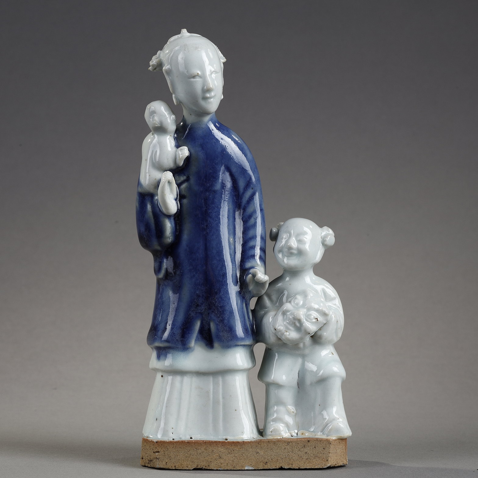 Blue White : charming blue white porcelain group of a young woman holding a baby and next to a child carrying in her arms a mask
China  Qianlong period  around 1750