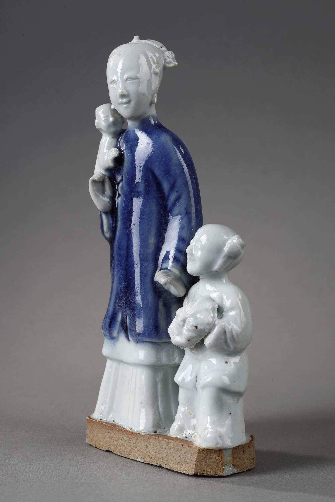 Blue White : charming blue white porcelain group of a young woman holding a baby and next to a child carrying in her arms a mask
China  Qianlong period  around 1750
