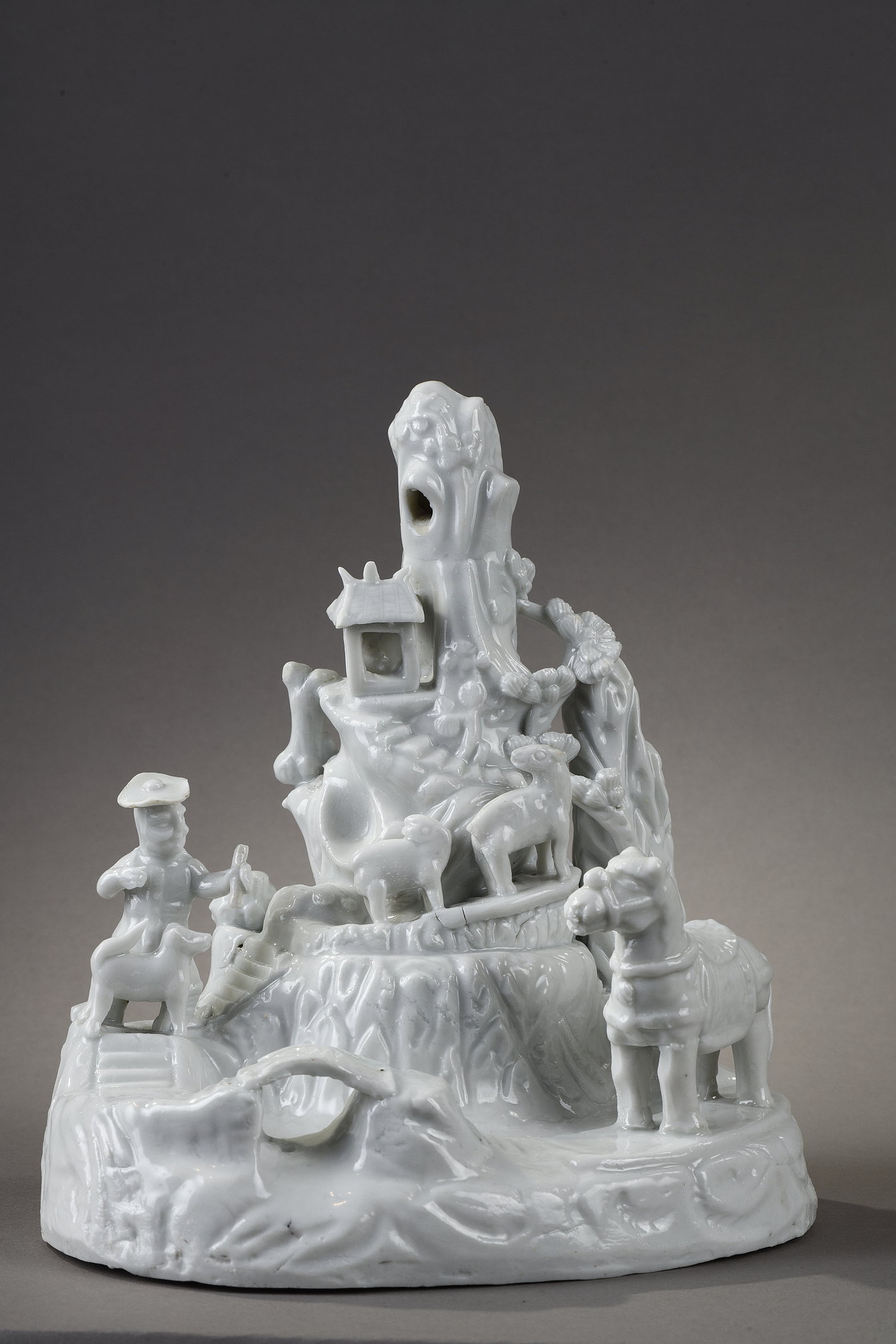 Bleu-Blanc : Groupe en porcelaine Blanc de Chine sculpté d un berger et animaux marchant dans la montagne , un chasseur occidental accompagné de son chien et en premier plan un cheval - Chine fours de Dehua province du Fujian 
Chine epoque Kangxi 1662/1722