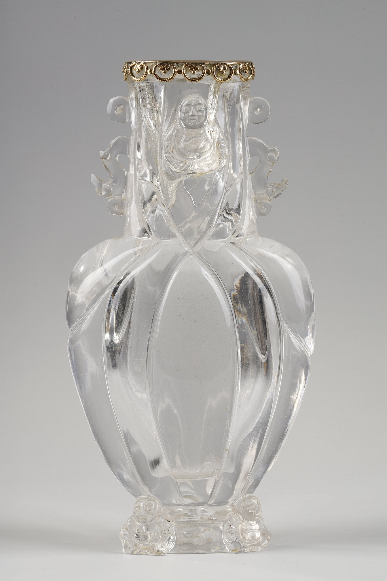 Works of Art : Carved rock crystal vase, the polylobed body, budai leaning against the foot and collar, the handles in the shape of stylized dragons. China around 1900 
The collar rimmed with gold  in the shape of a lingzhi       H 13.6cm