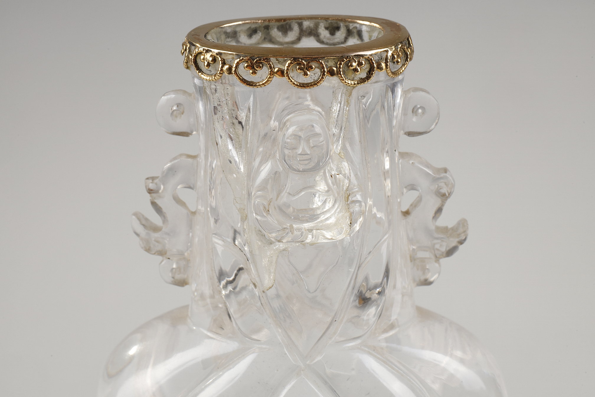 Works of Art : Carved rock crystal vase, the polylobed body, budai leaning against the foot and collar, the handles in the shape of stylized dragons. China around 1900 
The collar rimmed with gold  in the shape of a lingzhi       H 13.6cm