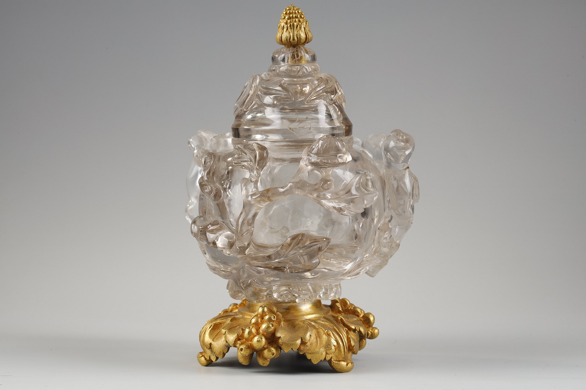 Works of Art : Carved rock crystal covered vase in the shape of a jug with a spout shaped like a bird’s head
China 19em siécle Posterior bronze mount adorned with bunches of grapes.   H 17cm