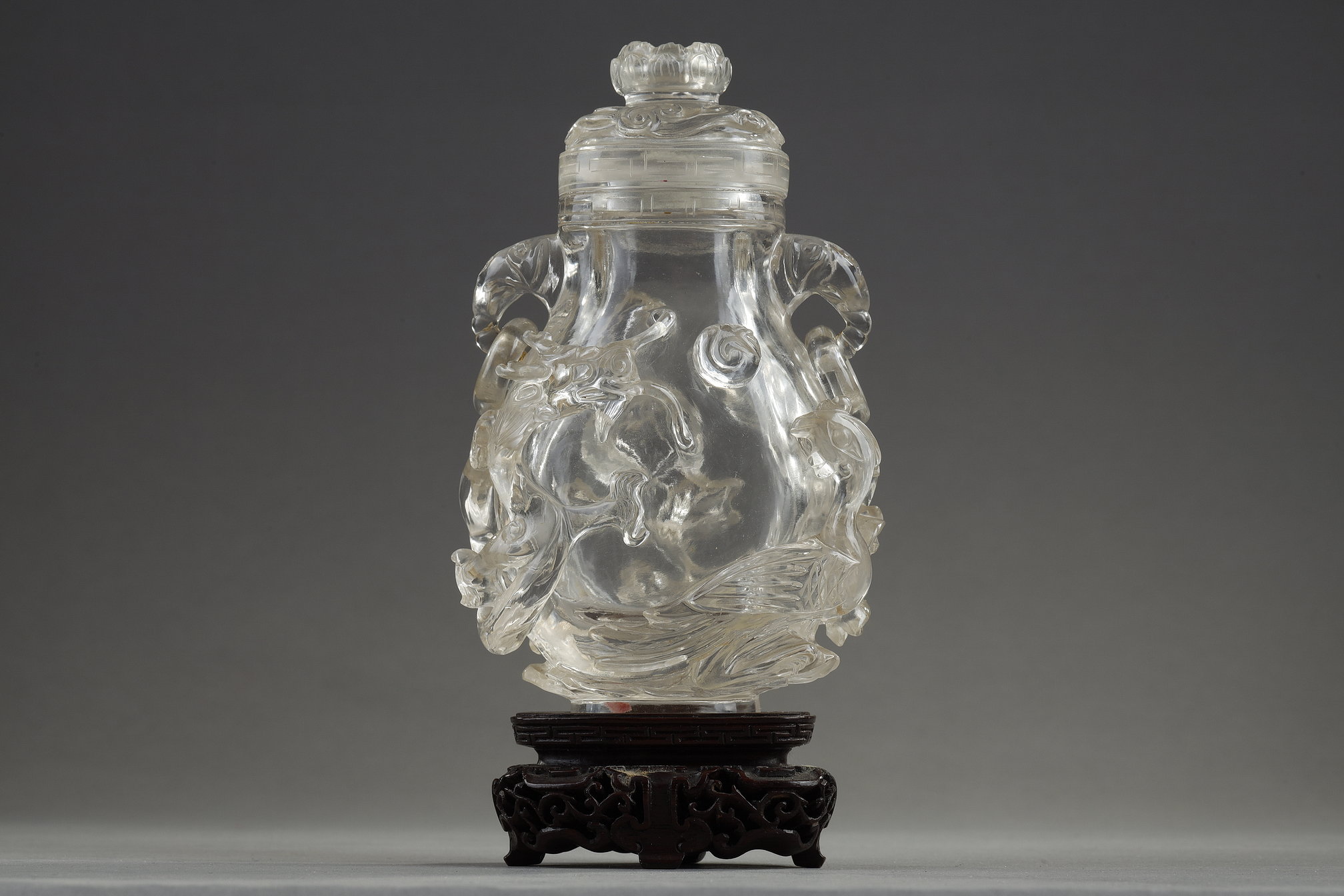 Objets d'art : Vase couvert en cristal de roche sculpté d un dragon chassant la perle et d un phoenix . Les anses à anneaux mobiles en tete d elephant . Et la prise du couvercle en fleurs de lotus  Chine 18/19em siècle 
H 12cm