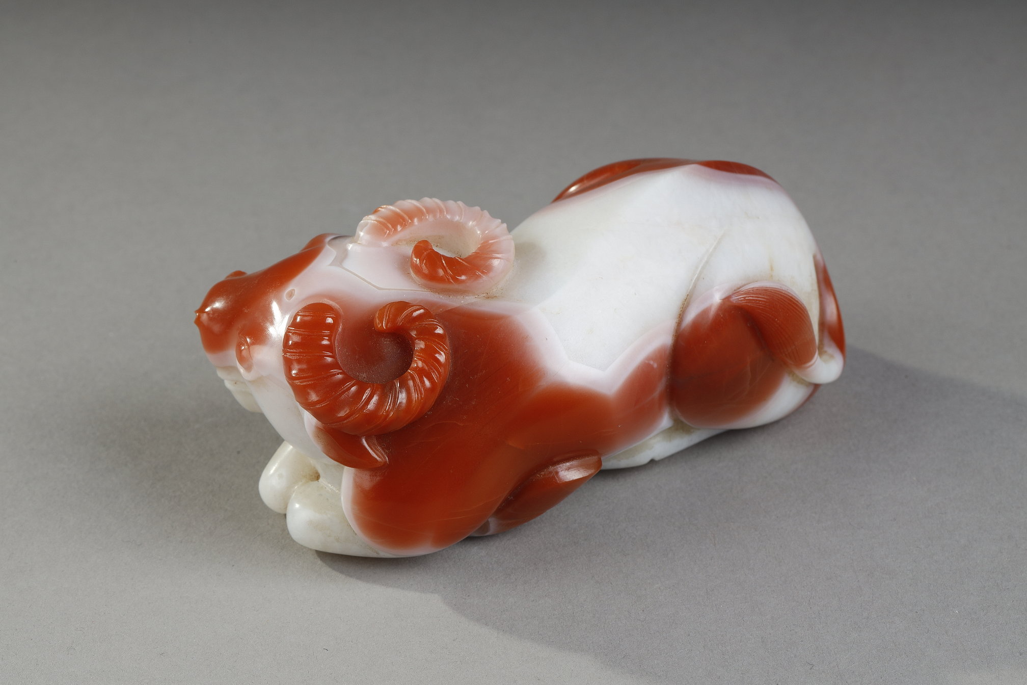 Works of Art : Statuette in white and rust carnelian representing a recumbent buffalo. China 19th century
10 cm long