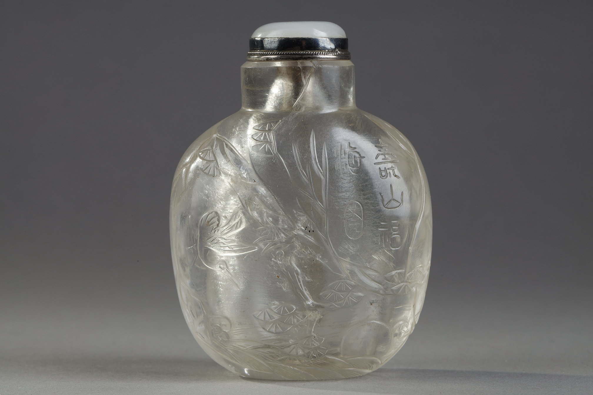 Tabatières : Tabatière en cristal de roche sculptée en leger relief avec Liu Hai , chauve souris et une grue pres d un rocher sous un pin . inscrit "Shou shan fu hai" (montagne de la longévité et mer du bonheur) sceau de Wen Yuan - le Maitre du Cristal Rustique  1730/1880