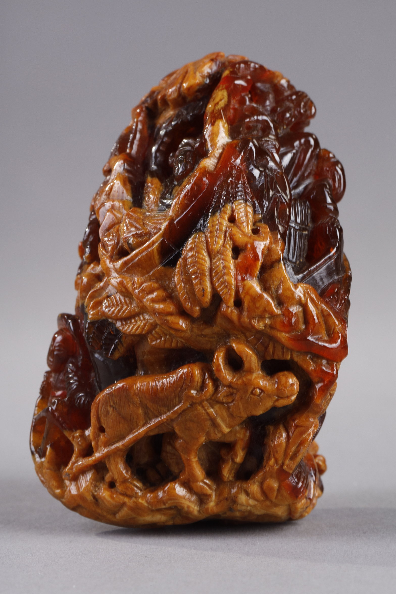 Works of Art : Pendant in amber root finely carved with a buffalo and several characters in a landscape - China 19th century