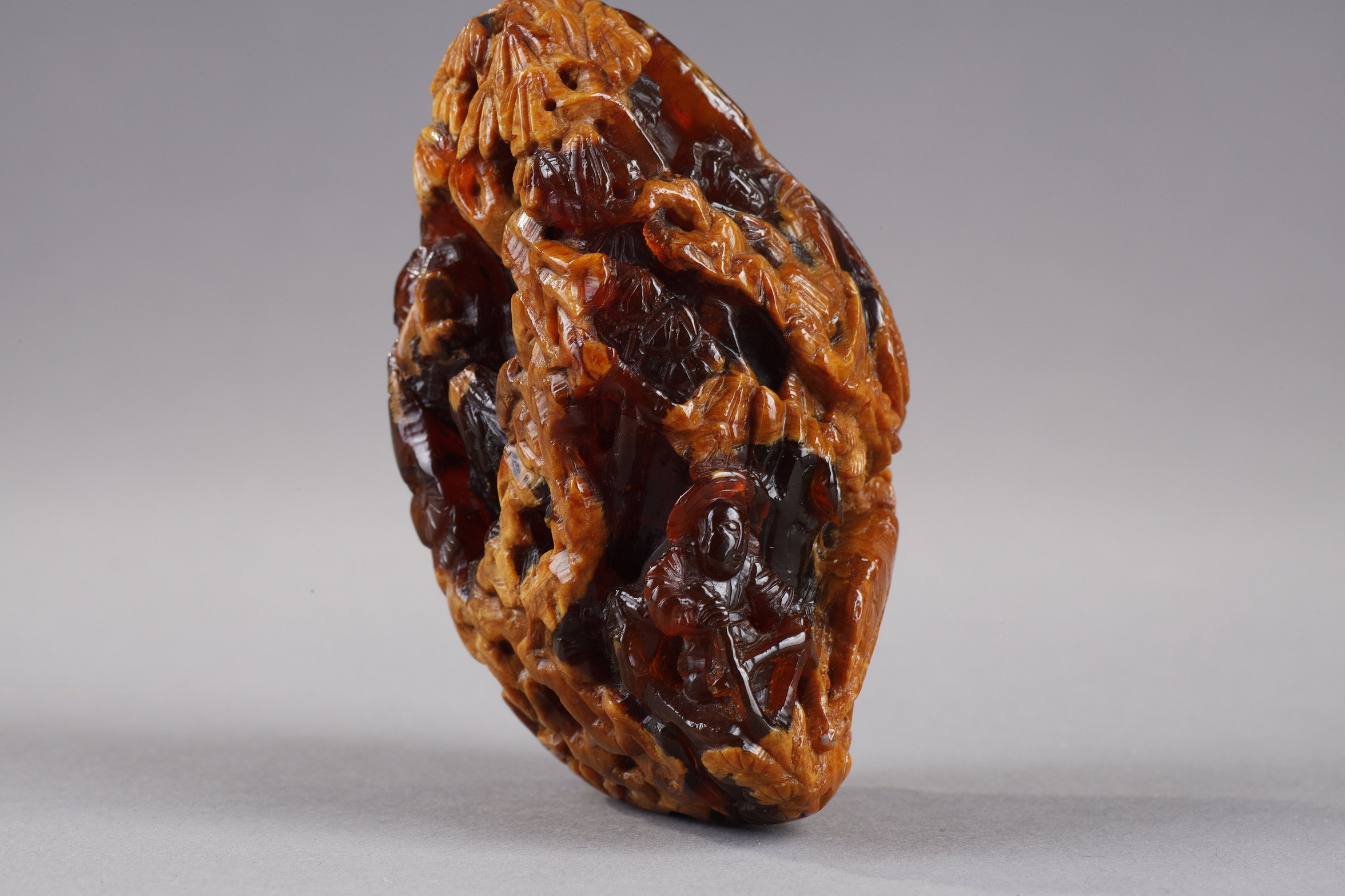 Works of Art : Pendant in amber root finely carved with a buffalo and several characters in a landscape - China 19th century