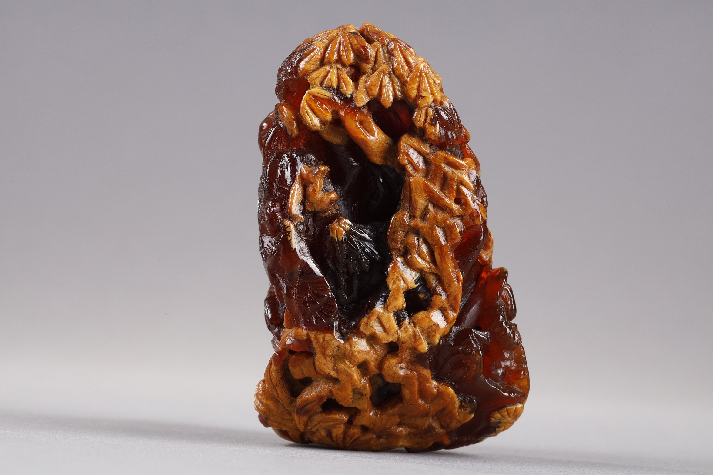 Works of Art : Pendant in amber root finely carved with a buffalo and several characters in a landscape - China 19th century