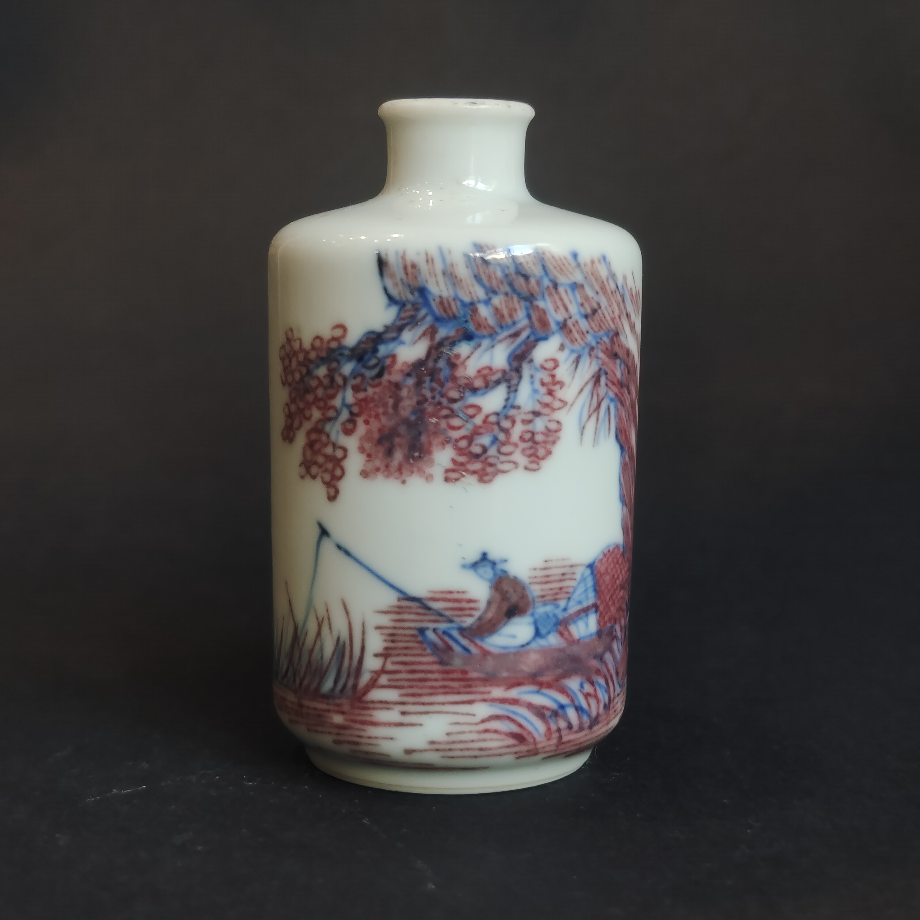 Snuff Bottles : porcelain snuffbottle decorated in copper red and blue under cover of a fisherman in a landscape
China 19th century