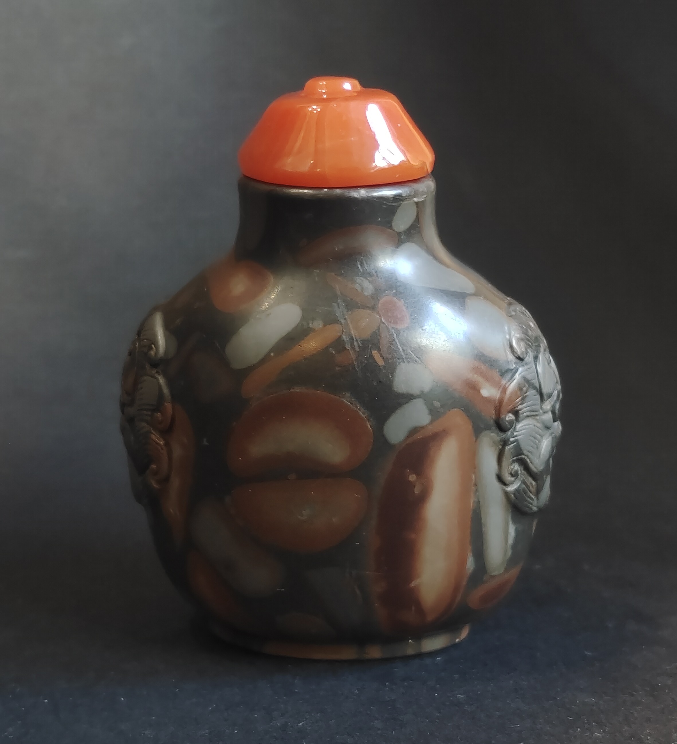 Snuff Bottles : Snuff bottle in puddingstone  sculpté de masques sur les cotés
Chine 19th century 