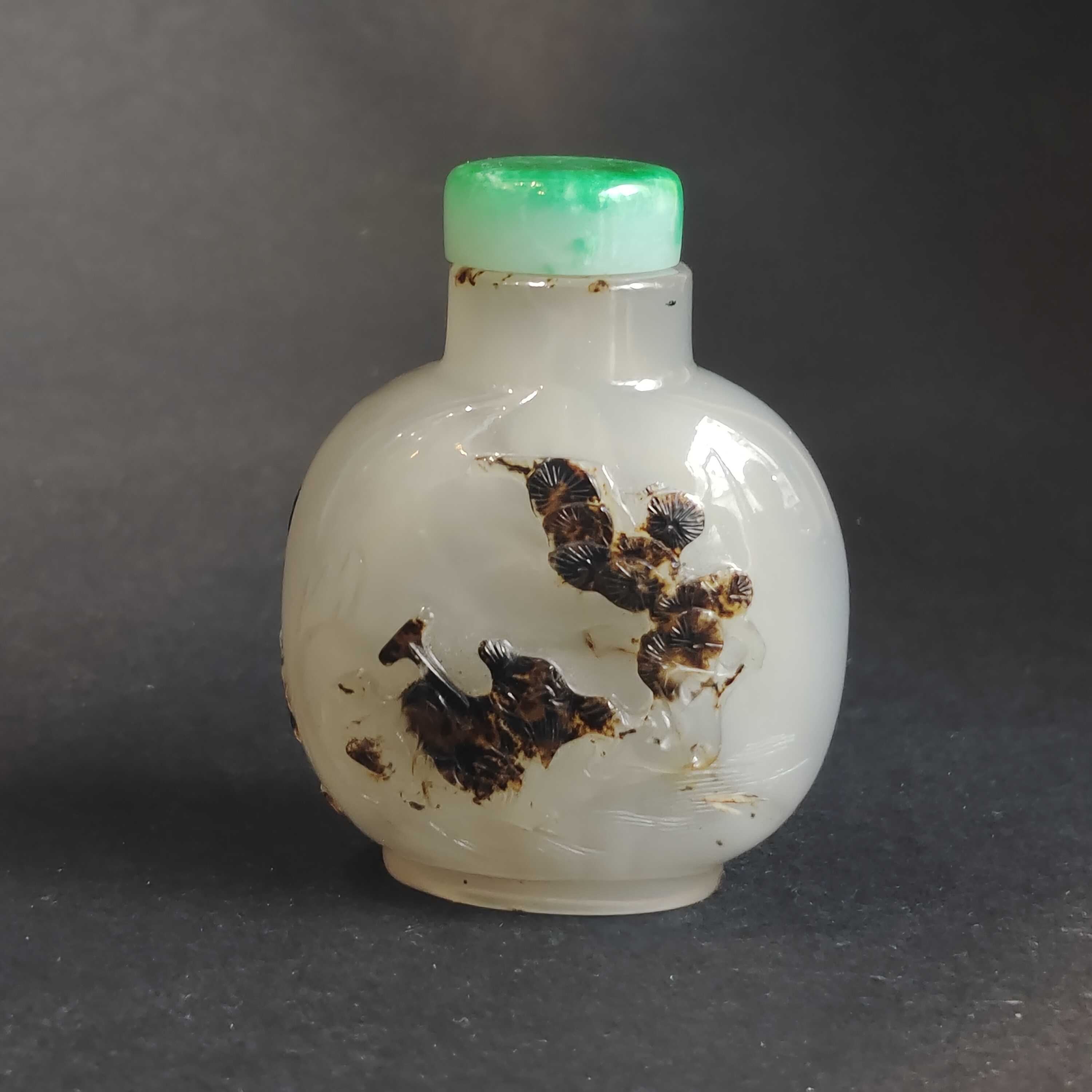 Snuff Bottles : Very well hollowed agate snuff bottle carved in a brown vein from a fisherman at the edge of the water with duck and frog near lotus and millet - on the reverse Zhang Qian on a tree trunk forming a boat -
China official school 1750/1850